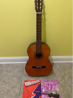 Acoustic guitar with case and books