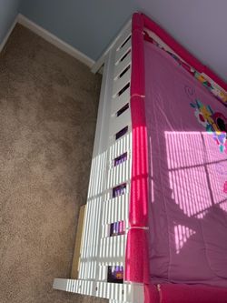White wooden toddler bed with storage drawers and stairs
