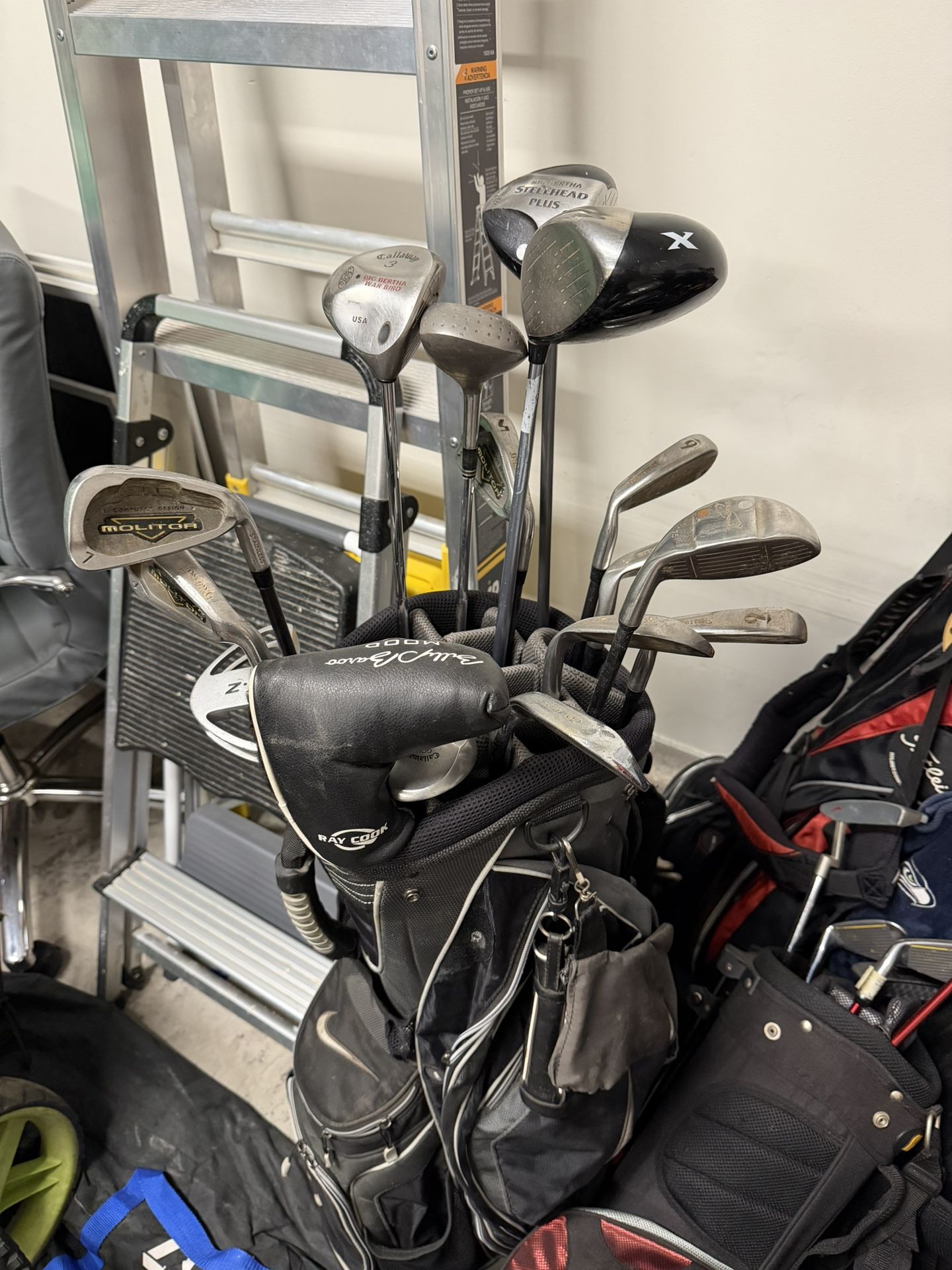 Fifteen golf clubs with a bag. Mixed brands, including Molitor irons, Callaway wood, Orlimar wood, wedges, and a Billy Baroo MOOD B100 putter.