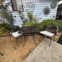 Wrought iron bistro set with two matching chair, chairs and cushions