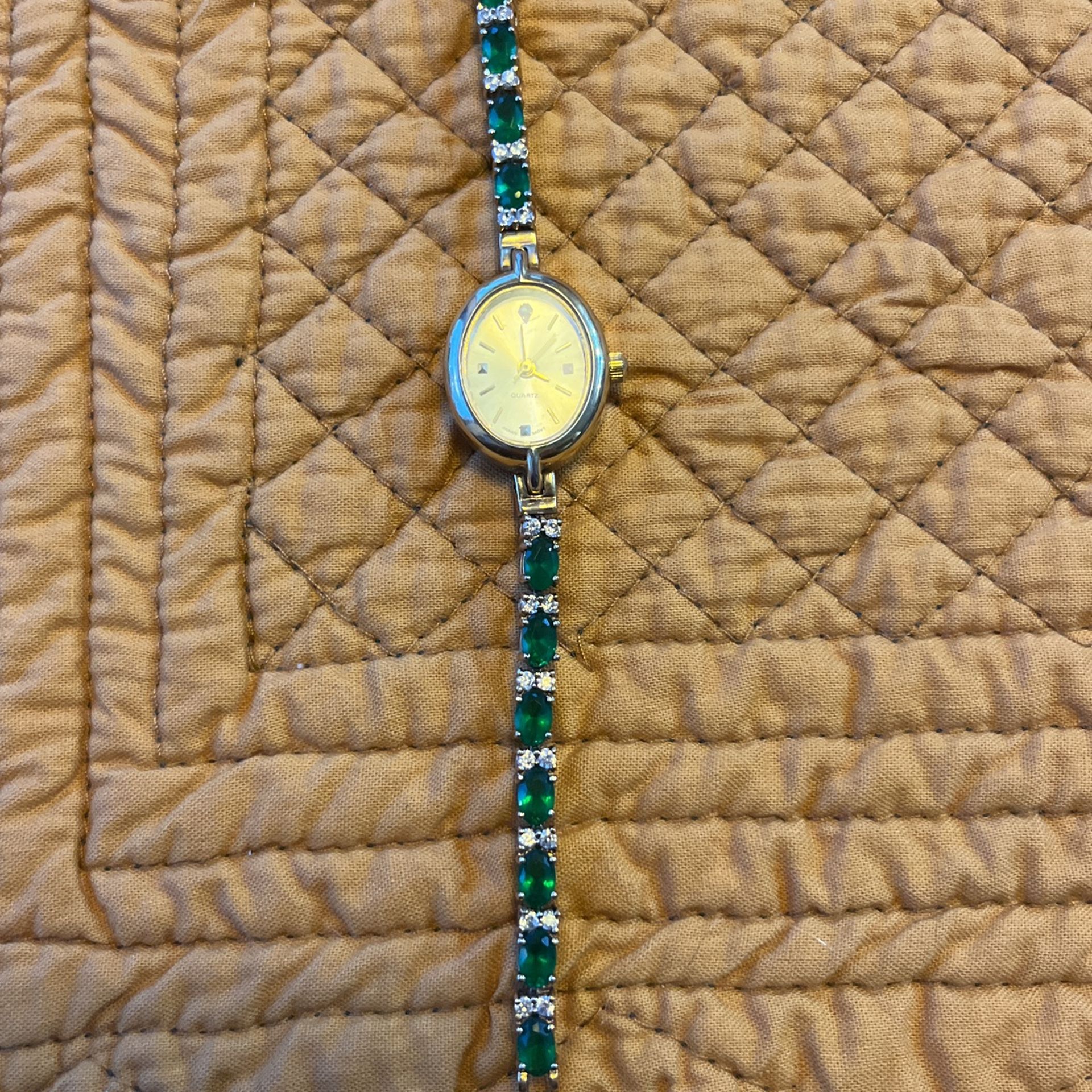 Emerald green stone tennis bracelet watch with oval face