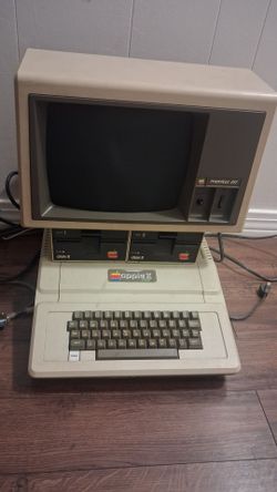 Apple II Plus computer paired with an Apple Monitor III. Games Included.