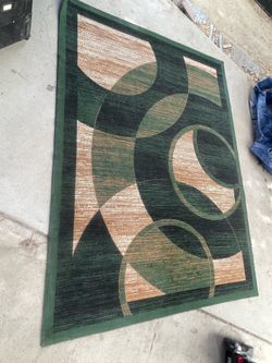Modern green and beige geometric area rug features a repeating abstract circular pattern