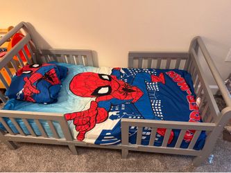 Toddler bed, mattress, waterproof mattress protector, and superhero toddler bedding.