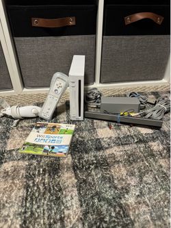 Nintendo Wii with controllers, cables, and Wii Sporta
