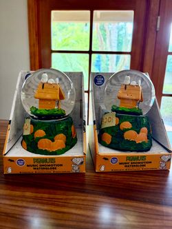 Collectible Peanuts Halloween music snomotion waterglobe in original packaging. Each waterglobe has Snoopy lying on an orange doghouse with a pumpkin 