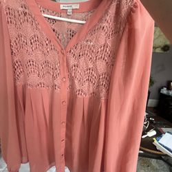 Salmon-colored blouse with a lace yoke and button-front closure.