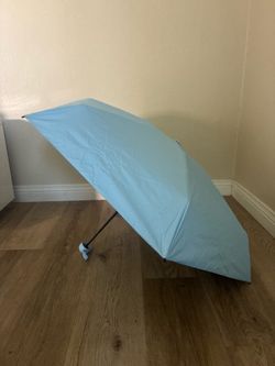 Small compact light blue umbrella