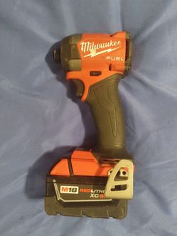 Milwaukee M18 FUEL Impact Driver with XC 5.0 BatteryPowerful Milwaukee M18 FUEL impact driver has a red and black plastic housing with a rubberized gr