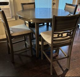 Grey for chair, tall dining set and a center coffee table with two chips on 2  corners off the table both for $160
