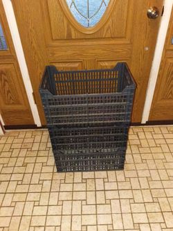 Three black plastic stackable storage crates