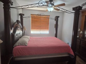 Queen size bed with two table lamps and a dresser