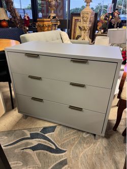modern 3-drawer dresser by Willa Arlo™ Interiors features a clean white finish and contrasting gold metal handles