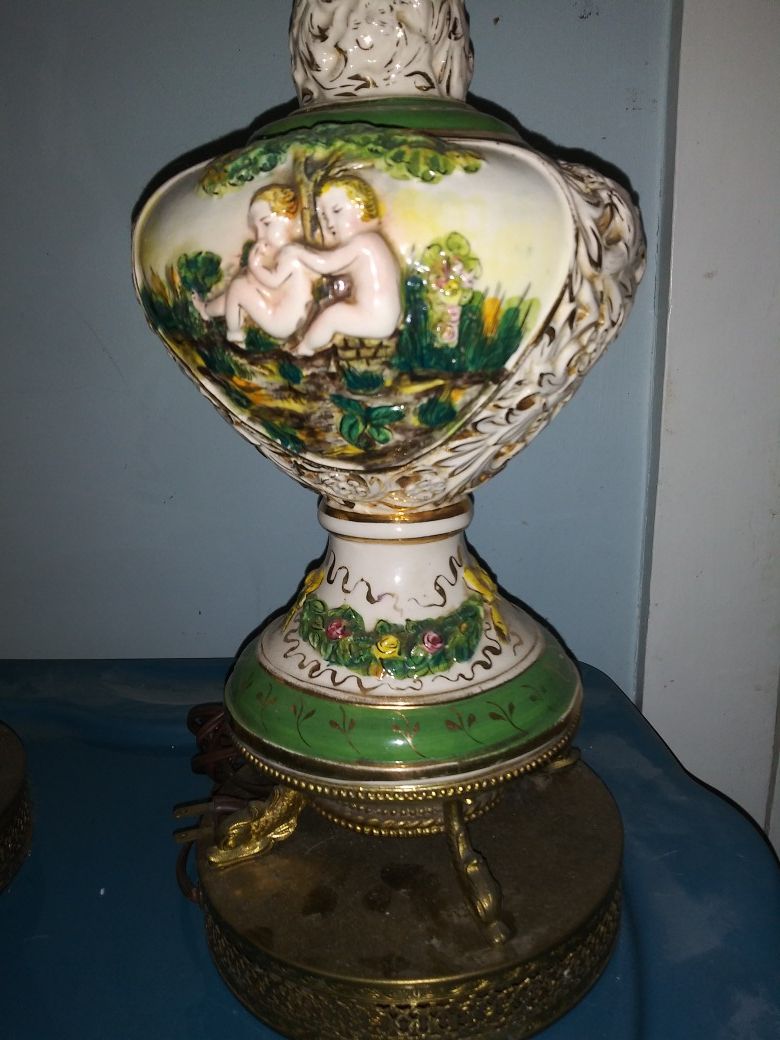 1930s porcelain lamps with cherubs sitting by a tree in a garden