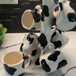 Cow-print ceramic mugs on a mug tree 