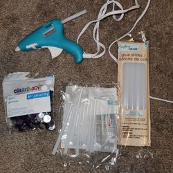 Glue gun, heart shape confetti, purple gems, and blue and pink petals