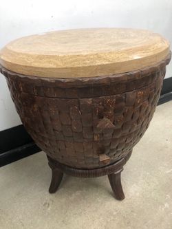 Schnadig nightstand features a textured drum base crafted from woven coconut wood and a light-colored tessellated stone top.