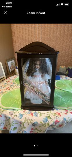 Porcelain Doll in wood cabinet