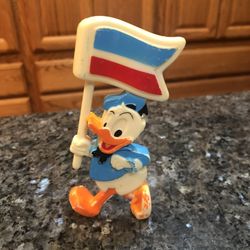Rare Vintage Old Disney Donald Duck Hard Plastic Figure holding a flag.  Stands up.  Size 4 1/2, inches tall.  Preowned.  Has been on display in a cab