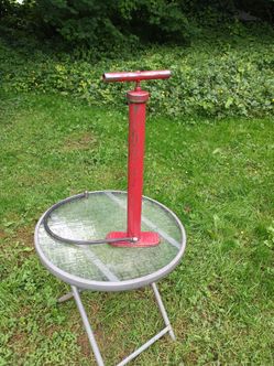 Vintage red metal floor bicycle and tire air pump.