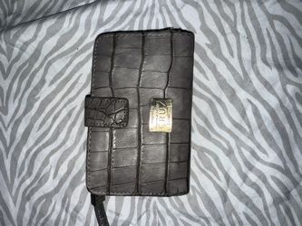 crocodile-embossed bifold wallet designed by Penélope and Mónica Cruz for Carpisa. 