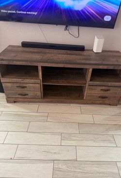 Signature Design by Ashley Trinell 63" TV stand in a warm rustic brown finish with industrial bronze