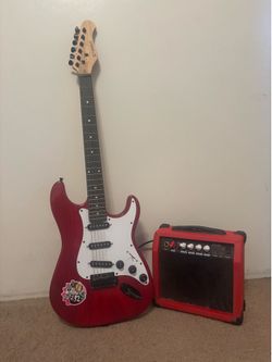 Red and white Stringo brand electric guitar and mini amplifier