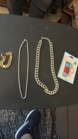Two chains and a golden bracelet and a bottle opener