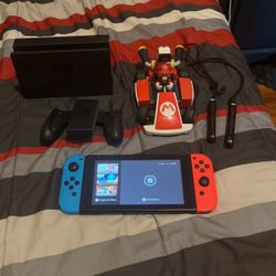 nintendo switch with mario cart and other accessories.