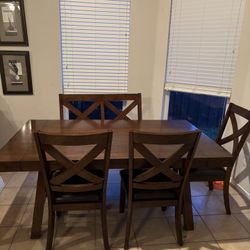 Dark wood dining table with 3 chairs and bench