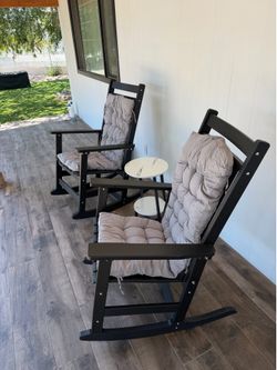 Black oversized rocking chairs with table