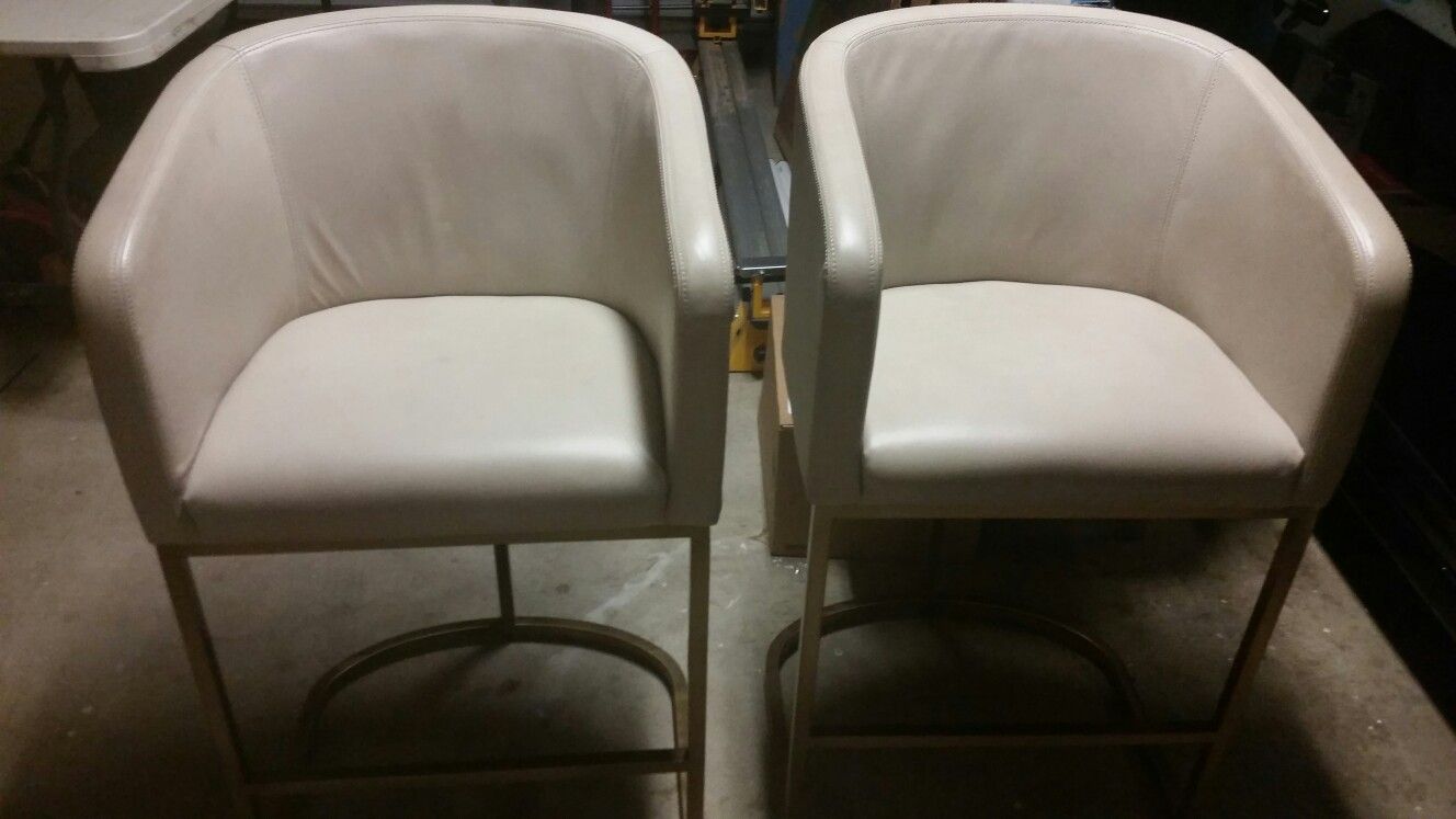 Two Restoration Hardware Modern leather and brass counter stools.