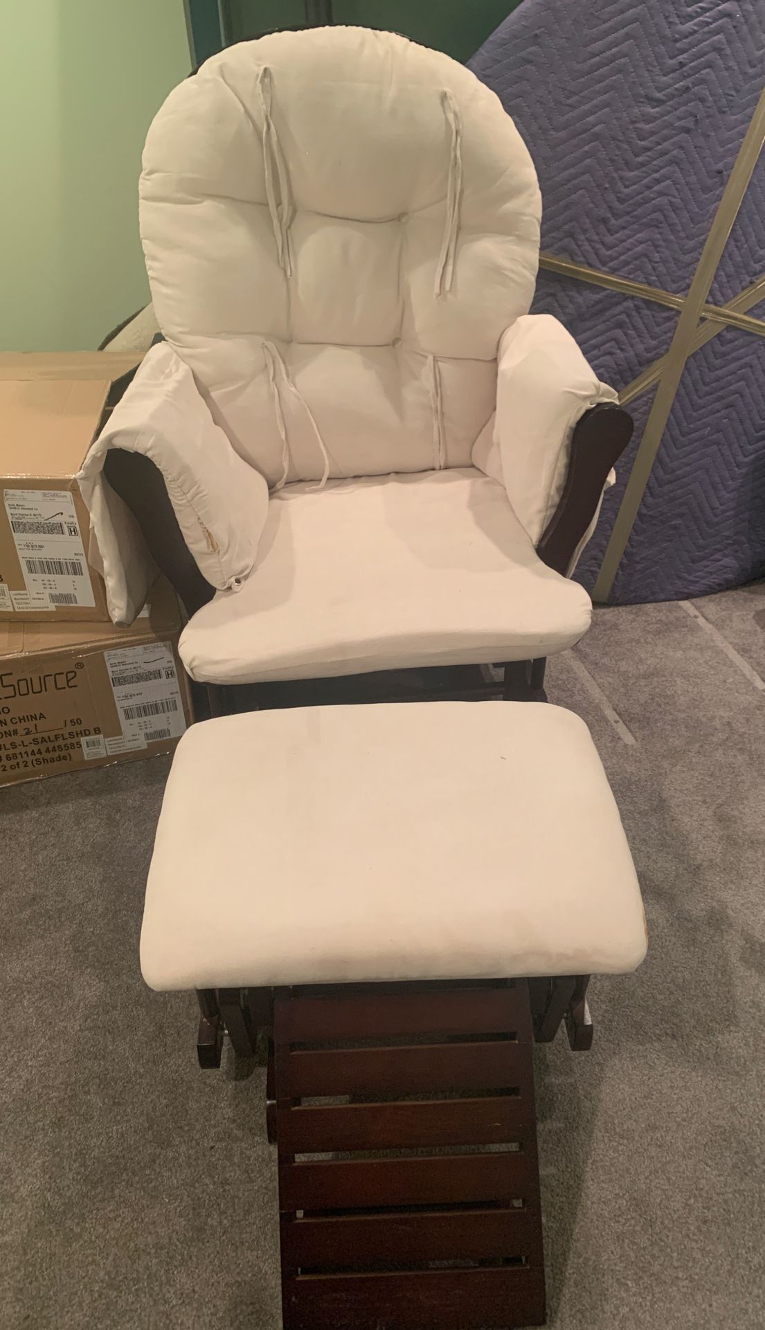 Wooden Rocking chair with foot rest white cushions.