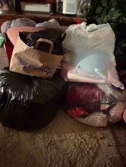 Various bags of clothes, bed linens, and curtains