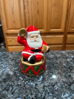 Ceramic Santa Claus Sitting On a Drum pair of salt and pepper shakers.  Size approximately 4 inches.  Preowned some minor paint wear.