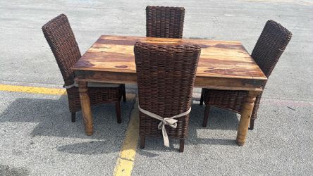 Pottery Barn Hayden dining set with a rectangular wood table and four woven wicker chairs.