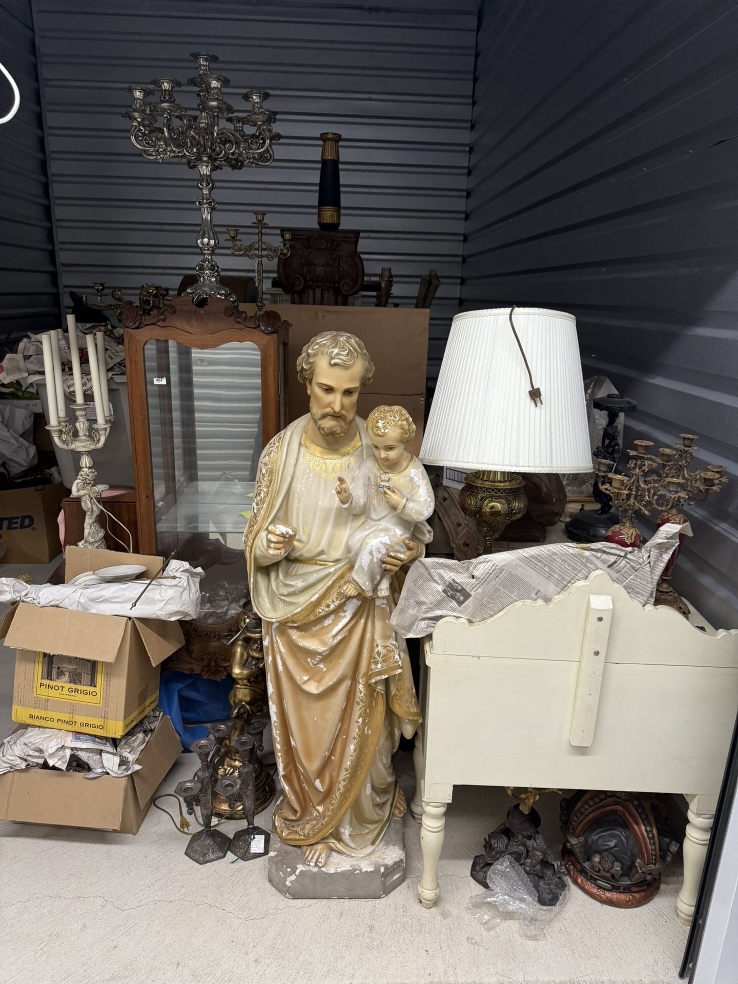 A large, vintage plaster statue of Saint Joseph holding the infant Jesus.