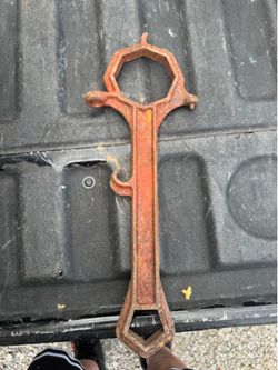 vintage fire hydrant spanner wrench made of red-painted cast iron.
