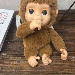 Toy monkey makes monkey sounds and sucks dumb
