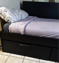 Black bed frame with a shelf and four pull out drawers