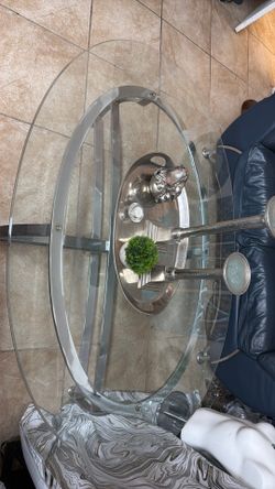 Hollywood regency style glass table, chrome metal base, oval glass top, silver finish base, (decor sold seperately)