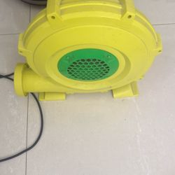 yellow and green machine pictured is an inflatable bounce house air blower