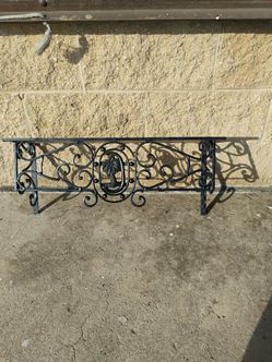 Black wrought iron wall-mounted window box or planter holder featuring decorative scrollwork and a central palm tree emblem. ( 26x11x8