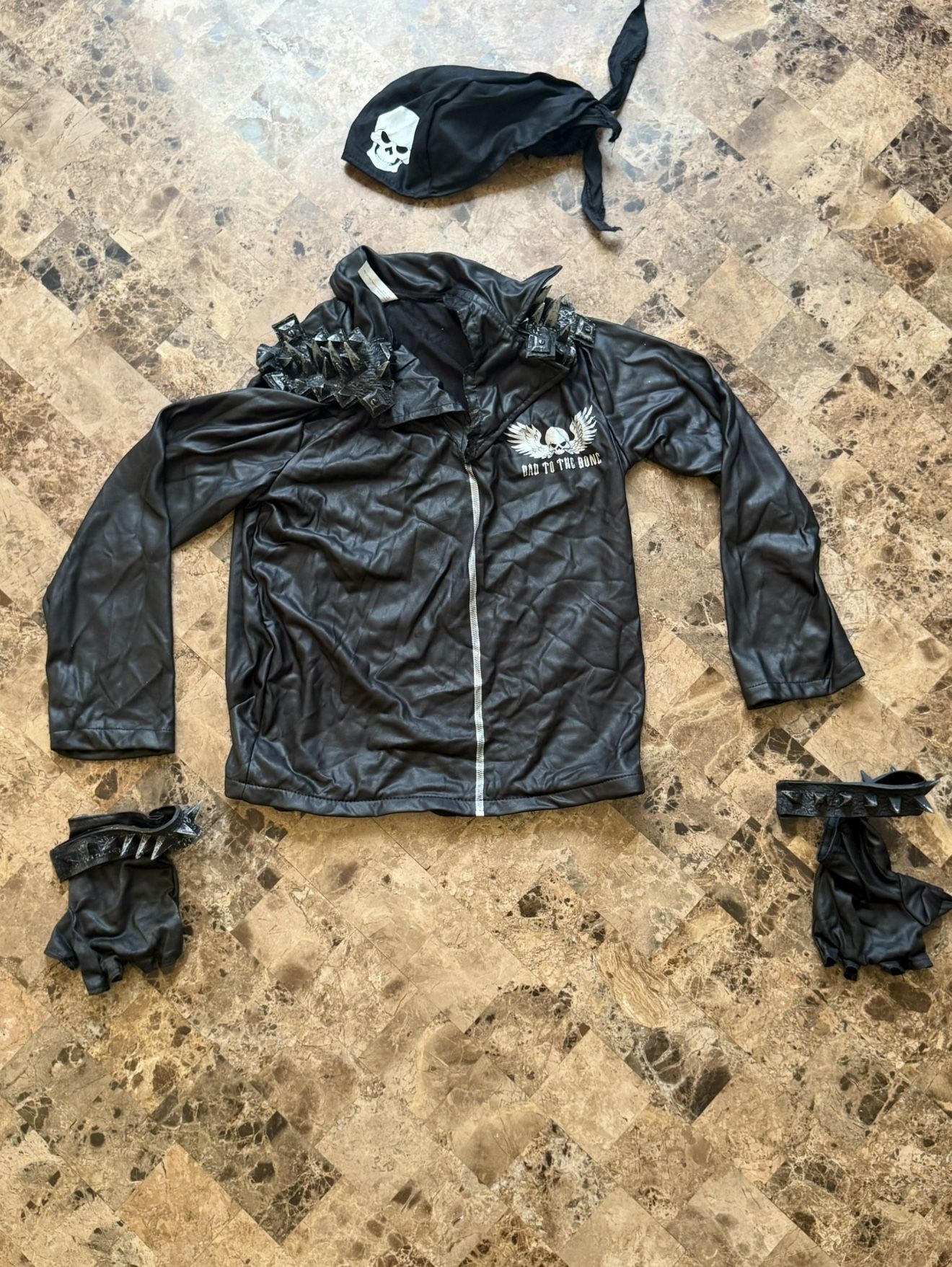 "Bad to the Bone" Halloween costume, featuring a faux leather jacket with silver latex spikes on the shoulders and a skull and wings graphic on the ch