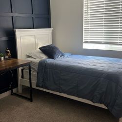 White twin bed with mattress and boxspring and nightstand