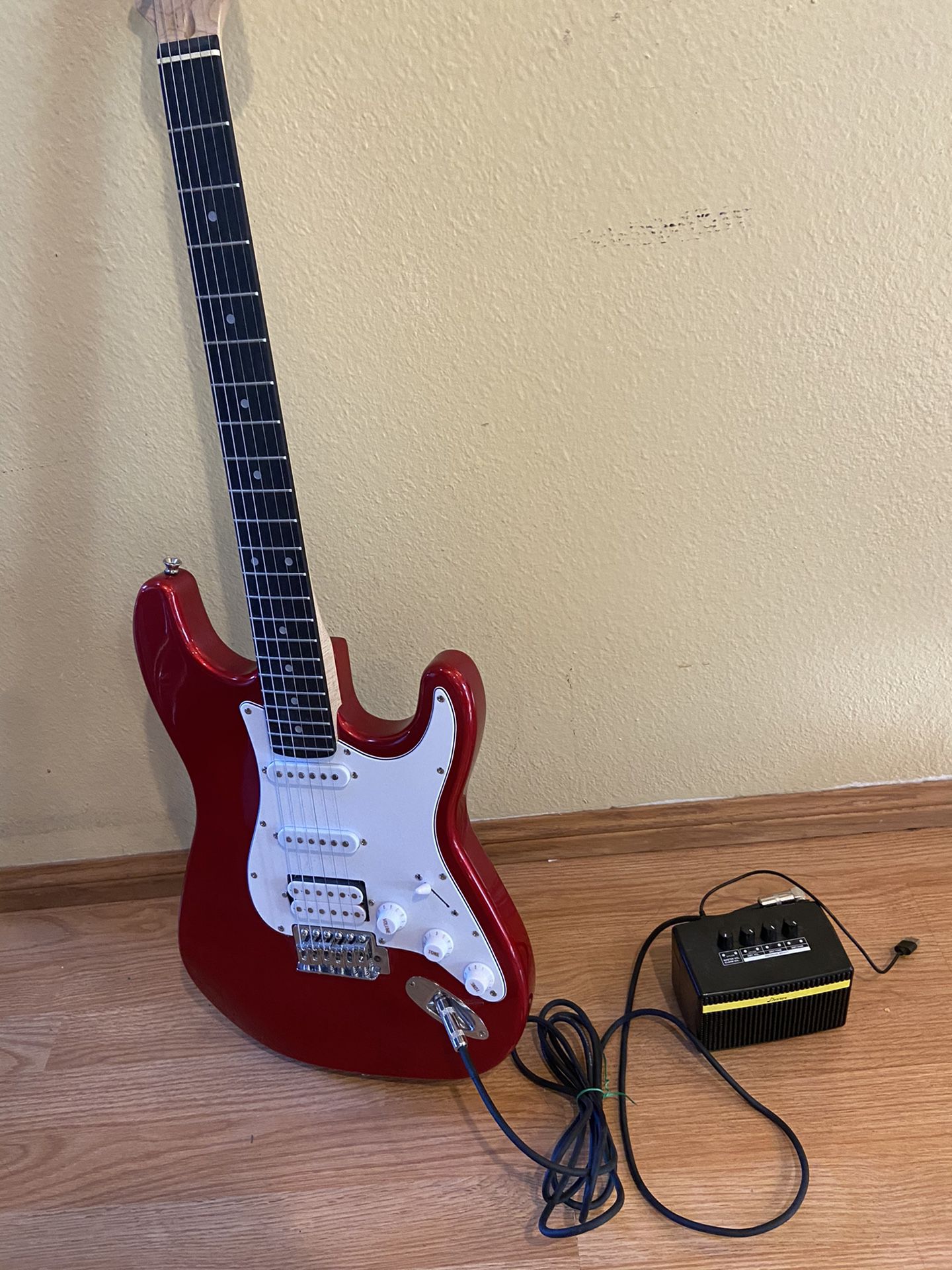 Electric guitar with cord and portable amp