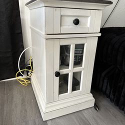 Night stand con conexión eléctrica para cargar teléfonos.