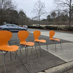 (4) Orange Stackable Modern Designer Dining/Lounge/office Chairs with chrome legs