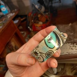 vintage mod pop acrylic plastic bangle bracelet with an inner turquoise and black pop swirl painted pattern and applied rhinestone flower clusters. 