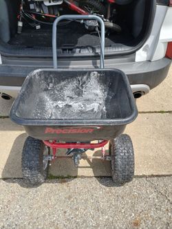 Precision tow behind 200 lb salt spreader we had to change the bar because of the other bar got damaged and Storage but it works great wheels are full